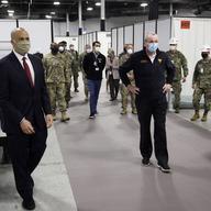 Sen. Cory Booker, D-N.J., left, and New Jersey Gov. Phil Murphy, right, tour the Edison Field Medical Station at the site of the N.J. Convention & Exposition Center in Edison, N.J.