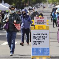 Masked customers walk through the West Seattle Farmers Market during its first opening in nearly two months because of the coronavirus outbreak Sunday, May 3, 2020, in Seattle.