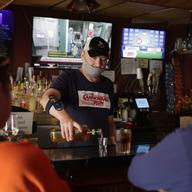 Bartender Greg Anderson, left, pours drinks for customers on the first day Tuner's Bar and Grill has reopened after being closed in an effort to slow the spread of the coronavirus Monday, May 4, 2020.