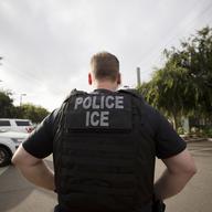 In this July 8, 2019, file photo, a U.S. Immigration and Customs Enforcement (ICE) officer looks on during an operation in Escondido, Calif.
