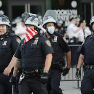 New York Police Officers pass the Barclays Center after protesters departed a rally for George Floyd, Tuesday, June 2, 2020, in the Brooklyn borough of New York.