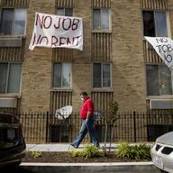 In this May 20, 2020, file photo, signs that read 'No Job No Rent' hang from the windows of an apartment building during the coronavirus pandemic in Northwest Washington.