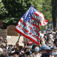 A protester waves an American flag with a message that reads 'CAN'T BREATHE' during a memorial for George Floyd at Cadman Plaza Park in the Brooklyn borough of New York, on Thursday, June 4, 2020. 