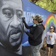Artist Melissa Penny paints a mural depicting George Floyd as her daughter Anabelle Penny watches on Wednesday, June 10, 2020, in Vallejo, Calif. 
