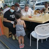 Mayor de Blasio dined with his wife, Chirlane McCray, right, as restaurant owner Melba Wilson sits with them at an outdoor booth at Melba's restaurant in Harlem on the first day of phase 2 reopening.