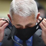 Director of the National Institute of Allergy and Infectious Diseases Dr. Anthony Fauci takes off his face mask before testifying before a House Committee on Energy and Commerce.