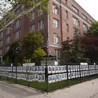 Individual student photographs of Brooklyn's James Madison High School graduating class of 2020, who were unable to walk a graduation stage this year due to the coronavirus pandemic, line the fence.