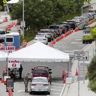 Vehicles wait in line at a COVID-19 testing site at the Miami Beach Convention Center during the coronavirus pandemic, Sunday, July 12, 2020, in Miami Beach, Fla. 