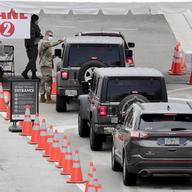A member of the Florida National Guard directs vehicles at a COVID-19 testing site at the Miami Beach Convention Center during the coronavirus pandemic, Sunday, July 12, 2020, in Miami Beach, Fla. 