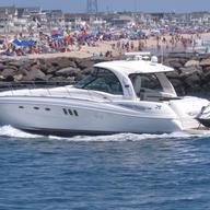 In this June 28, 2020, a yacht cruises through the Manasquan Inlet as a large crowd fills the beach in Manasquan, N.J. 
