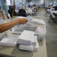 A worker gathers a bundle of ballots as they are processed at a Board of Elections facility, Wednesday, July 22, 2020, in New York.