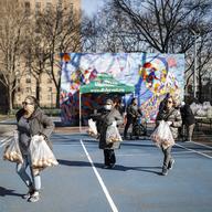 Volunteers wear protective gloves and face masks as they handle pre-bagged food donations at City Harvest's Bed-Stuy Mobile Market operating in the Tomkins Houses area, Wednesday, March 18, 2020.