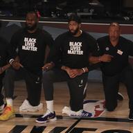 Los Angeles Lakers' LeBron James, second from left, wears a Black Lives Matter shirt and kneels with teammates during the national anthem prior to an NBA basketball game against the LA Clippers.