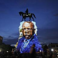 In this Wednesday, July 22, 2020 file photo, an image of the late Georgia Congressman and civil rights pioneer U.S. Rep. John Lewis is projected on to the pedestal of the statue of confederate Gen. Ro
