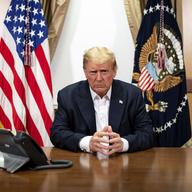 President Donald Trump sits at a desk at Walter Reed Medical Center