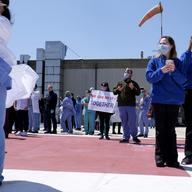Doctors, nurses and other staff members at University Hospital watch a flyover from the helipad of the hospital in Newark, N.J., Tuesday, May 12, 2020.