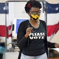 Donta Stevenson carries her ballot to be processed as she votes at the Martha O'Bryan Center on Election Day Tuesday, Nov. 3, 2020, in Nashville, Tenn.