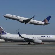 In this Oct. 15, 2020, file photo, a United Airlines airplane takes off over a plane on the runway at San Francisco International Airport in San Francisco.