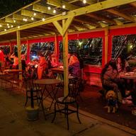 People eating outside in a covered vestibule.