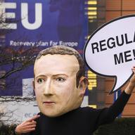 A campaigner from the global citizens movement Avaaz wearing a mask of Facebook CEO Mark Zuckerberg holds a sign reading 'Regulate me' on Tuesday, Dec. 15, 2020 in Brussels.