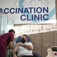 Ambulatory Care Technician Sady Ferguson gives a COVID-19 vaccine to Justin Sambol, senior associate dean for clinical affairs at Rutgers New Jersey Medical School, at University Hospital in Newark, N