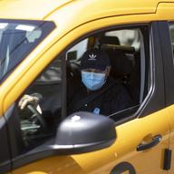 Taxi driver Nicolae Hent, wearing a protective mask, drives his taxi in New York, Monday, April 6, 2020. 