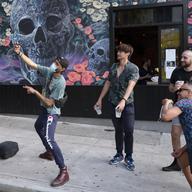 A man takes photos with friends outside a bar in the Hell's Kitchen neighborhood of New York, Friday, May 29, 2020, during the coronavirus pandemic.