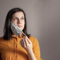 a white woman looking off screen taking off her mask