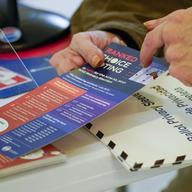 An election worker goes over a ranked choice voting explanation card with a voter before she casts her vote during early voting in the primary election, Monday, June 14, 2021, at the Church of St. Ant