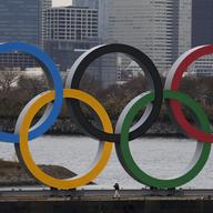 A worker is dwarfed by the Olympics Rings on a barge Friday, Jan. 17, 2020, in the Odaiba district of Tokyo.