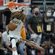 Milwaukee Bucks forward Giannis Antetokounmpo, top, dunks over Phoenix Suns guard Chris Paul during the second half of Game 5 of basketball's NBA Finals, Saturday, July 17, 2021, in Phoenix. 