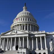 looking up at the u.s. capitol building on a cloudless day