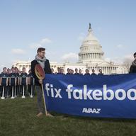 Men with sign saying 'Fix fakebook' stand next to of 100 cardboard Mark Zuckerbergs in front of the U.S. Capitol