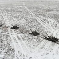 Aerial view of four Russian tanks in a snowy field.