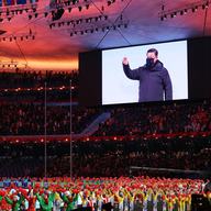 A man on a big TV screen above a crowd.