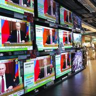 Multiple screens show Vladimir Putin with captions in Chinese