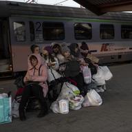 A Ukrainian family who fled the war wait at the train station in Przemysl, southeastern Poland, on Sunday, March 13, 2022. 