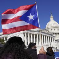 A woman waves the flag of Puerto Rico during a news conference on Puerto Rican statehood on Capitol Hill in Washington, Tuesday, March 2, 2021.