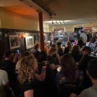 Audience members watching musicians in a small nightclub.