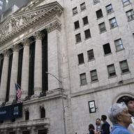 Pedestrians pass the New York Stock Exchange, Thursday, May 5, 2022, in the Manhattan borough of New York.