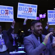 Members of the crowd hold up signs as President Joe Biden speaks at the 40th International Brotherhood of Electrical Workers (IBEW) International Convention at McCormick Place, Wednesday, May 11, 2022