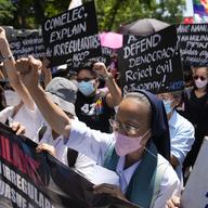 A Catholic nun clenches her fist as she joins protesters against presidential frontrunner Ferdinand 'Bongbong' Marcos and running mate Sara Duterte, daughter of the current president, during a rally.