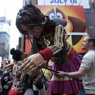 A woman hugs a 12-foot-tall puppet on Times Square.