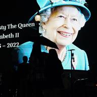 People pass by an image of Queen Elizabeth II projected onto a large screen at Piccadilly Circus, in London, Thursday, Sept. 8, 2022. 