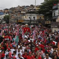 A large doll in the likeness of Brazil's former President Luiz Inacio Lula da Silva, who is running for office again, is paraded through the Complexo do Alemao favela at his campaign rally