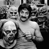 Tom Savini tugs on the hair of one of the monster masks in his Pittsburgh home while other masks from movies such as 'Friday The 13th', 'Dawn of The Dead' and 'Creepshow' drape his room.