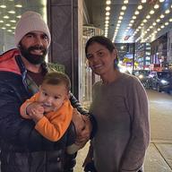 David Lopez and Carmen Benitez with their baby in front of a Times Square hotel.