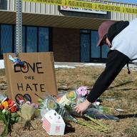 Elijah Newcomb of Colorado Springs lays flowers near a gay nightclub in Colorado Springs, Colo., Sunday, Nov. 20, 2022 where a shooting occurred late Saturday night.