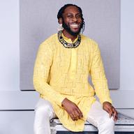 A man in a bright yellow shirt, with a beaming smile