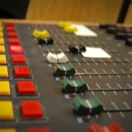 A radio control board with different colored faders.